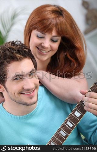 Young couple with a guitar at home