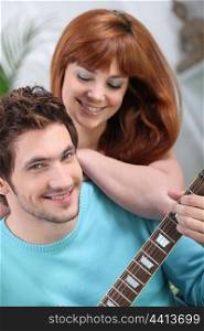 Young couple with a guitar at home