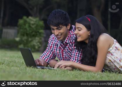 Young couple with a laptop in a park
