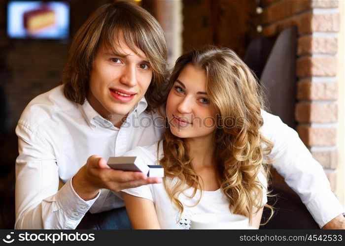 Young couple with a ring during an engagement in a restaurant