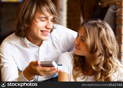 Young couple with a ring during an engagement in a restaurant