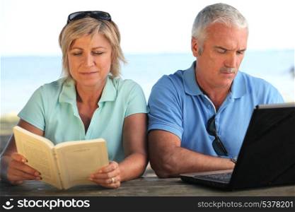 Young couple with book and computer