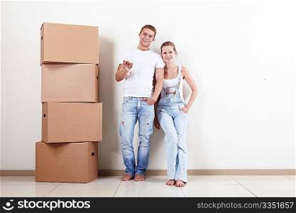 Young couple with boxes and flat keys