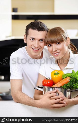 Young couple with capacity with vegetables in the foreground