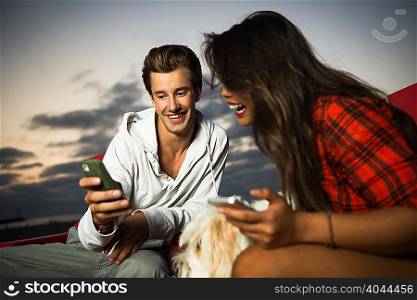 Young couple with cell phone, San Diego, California, USA
