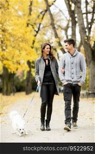 Young couple with dog in the autumn park