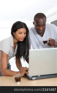 Young couple with laptop computer in home kitchen