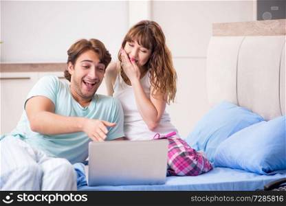 Young couple with laptop in the bedroom 