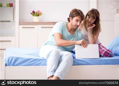 Young couple with laptop in the bedroom 