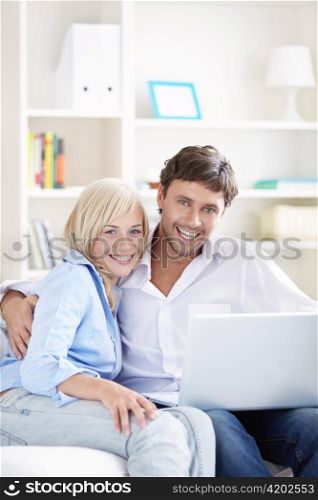 Young couple with laptop on a couch