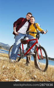 Young Couple with Mountain Bike low angle view.