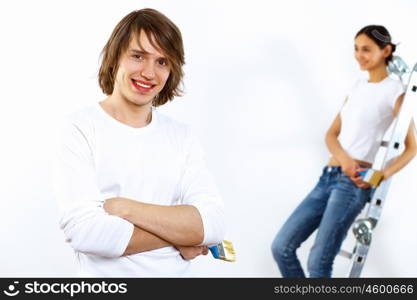 Young couple with paint brushes doing renovation together