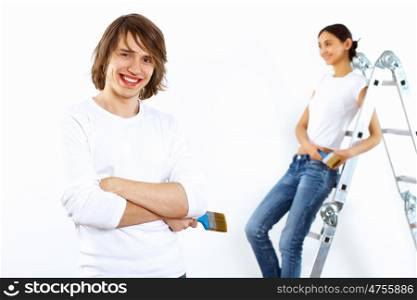 Young couple with paint brushes doing renovation together