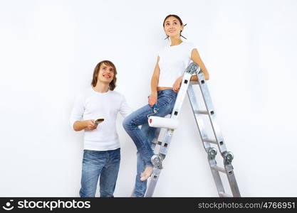 Young couple with paint brushes doing renovation together