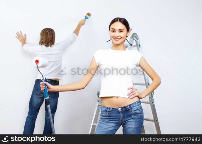 Young couple with paint brushes doing renovation together