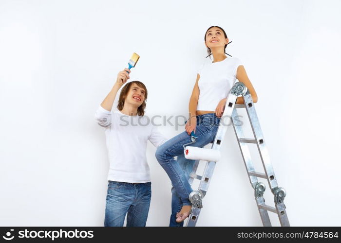 Young couple with paint brushes doing renovation together