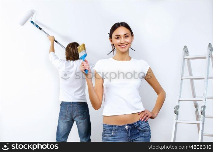 Young couple with paint brushes doing renovation together
