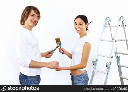 Young couple with paint brushes doing renovation together