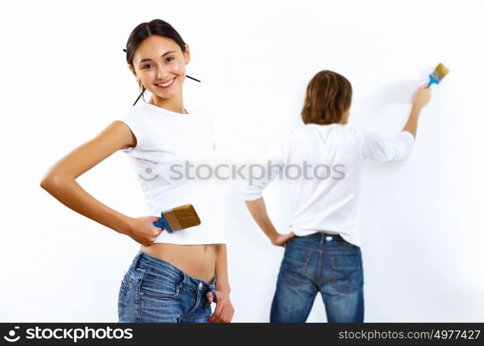 Young couple with paint brushes doing renovation together