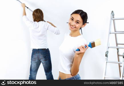 Young couple with paint brushes doing renovation together