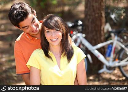 Young couple with stood by mountain bikes