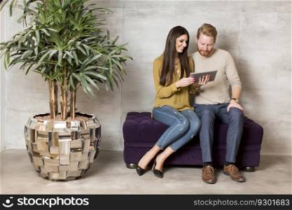 Young couple with tablet on sofa