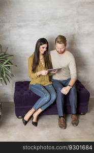 Young couple with tablet on sofa