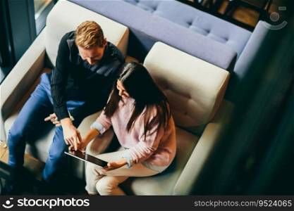 Young couple with tablet sitting in the cafe