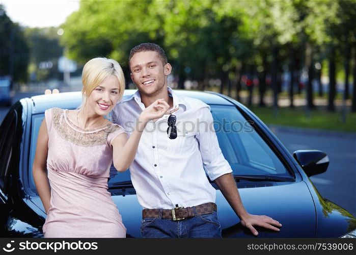 Young couple with the keys in car