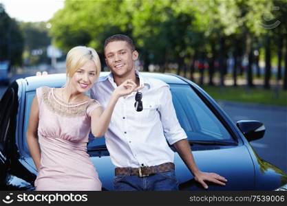 Young couple with the keys in car
