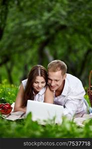 Young couple with the laptop in park