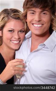 young couple with toothy smile and flute of wine