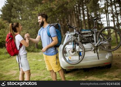 Young couple with trekking outfit standing in the forest and start the hike