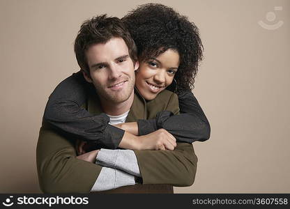 Young couple, woman embracing man from behind, portrait