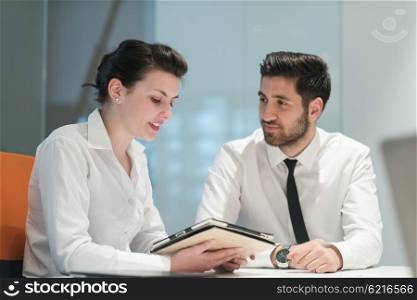 Young couple working together on tablet computer. Teamwork, help, support concept. Business group at modern startup office meeting room interior working online on project plans.