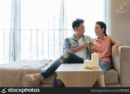 Young Couples celebrate together with wine in bedroom of contemporary house for modern lifestyle concept