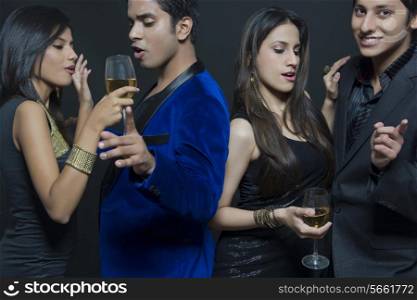 Young couples enjoying party over black background