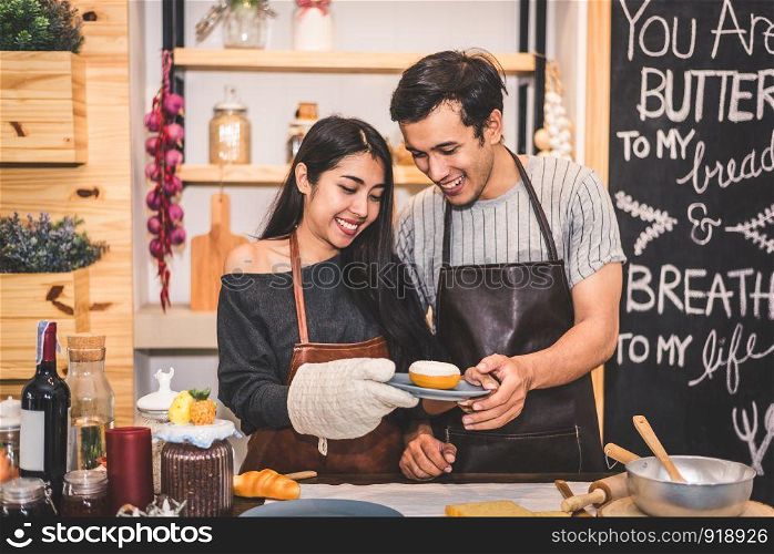 Young couples making bakery donuts and bread at bakery shop as business ownership entrepreneur. Husband and wife cooking together in kitchen. Happiness people and lifestyle relationship concept