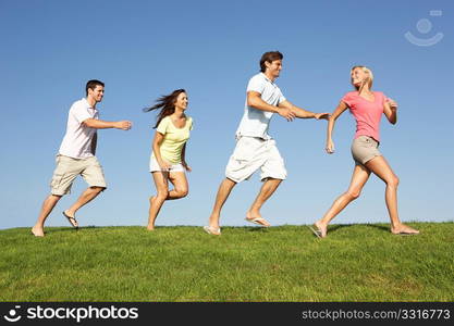 Young couples running through field