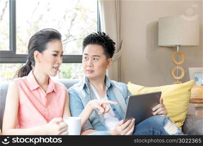 Young Couples using tablet tohether in living room of contemporary house for modern lifestyle concept