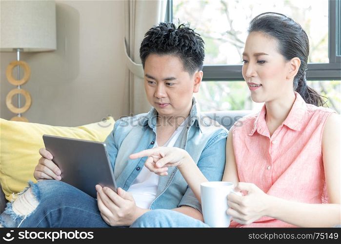 Young Couples using tablet tohether in living room of contemporary house for modern lifestyle concept