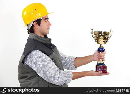 young craftsman in profile holding trophy