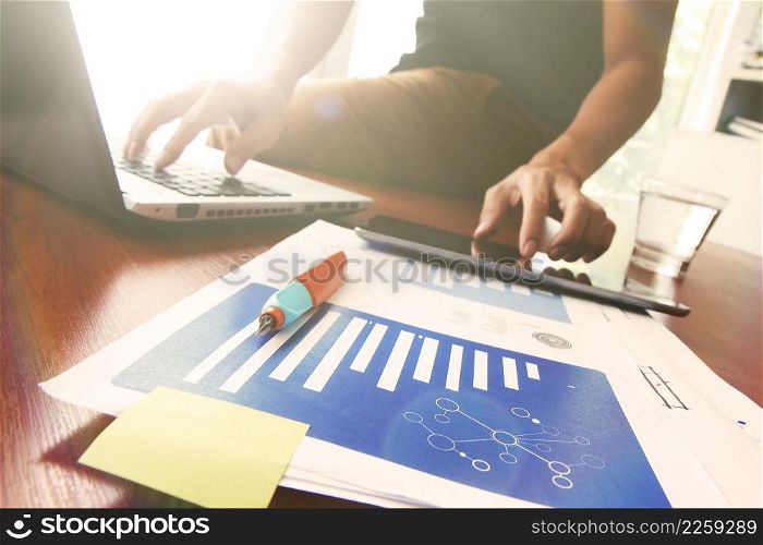 Young creative designer man working at office and social network media and graph chart diagram as concept with overcast exposure effect