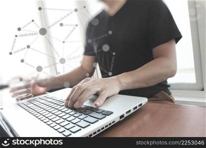 Young creative designer man working at office with computer laptop with social network diagram concept