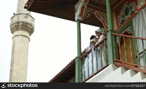 Young Crimean Tatar couple on the steps of the Big Khan Mosque in Bakhchisaray Palace. Bakhchisaray, Crimea, Ukraine