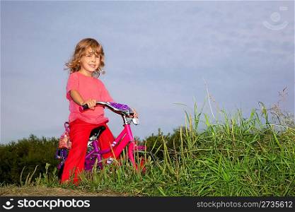 young curly girl biker rests in the field