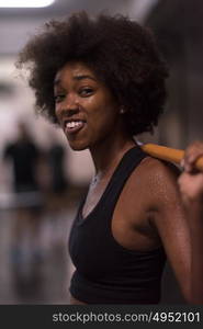 Young Cute african american sport woman in fitness room lifting empty bar