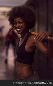 Young Cute african american sport woman in fitness room lifting empty bar