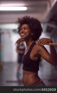 Young Cute african american sport woman in fitness room lifting empty bar