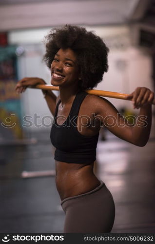 Young Cute african american sport woman in fitness room lifting empty bar